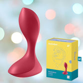 A red **Satisfyer Backdoor Lover Anal Vibrator** is showcased next to its yellow and blue packaging box labeled "Satisfyer Plug" with the model name "Satisfyer Backdoor Lover." The background features a blurry, sparkling light pattern, highlighting the sleek design of this premium anal vibrator by **Satisfyer**.